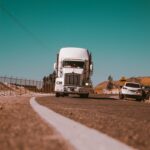 camion de marchandises blanc sur une route en béton gris
