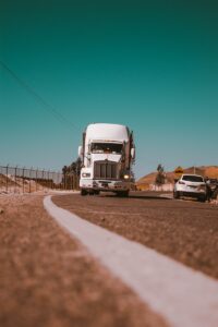 camion de marchandises blanc sur une route en béton gris