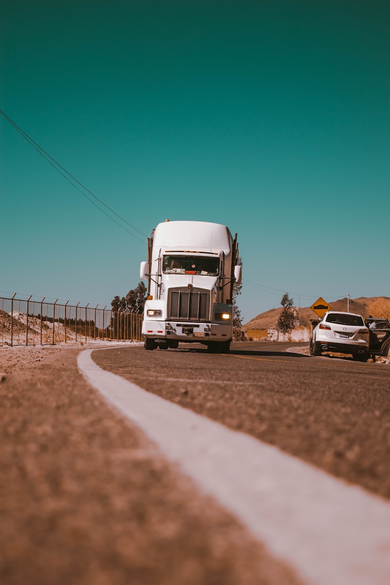 camion de marchandises blanc sur une route en béton gris