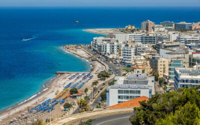 Superbe vue aérienne du paysage urbain et du littoral de Rhodes, mettant en valeur les plages animées et les eaux azur.