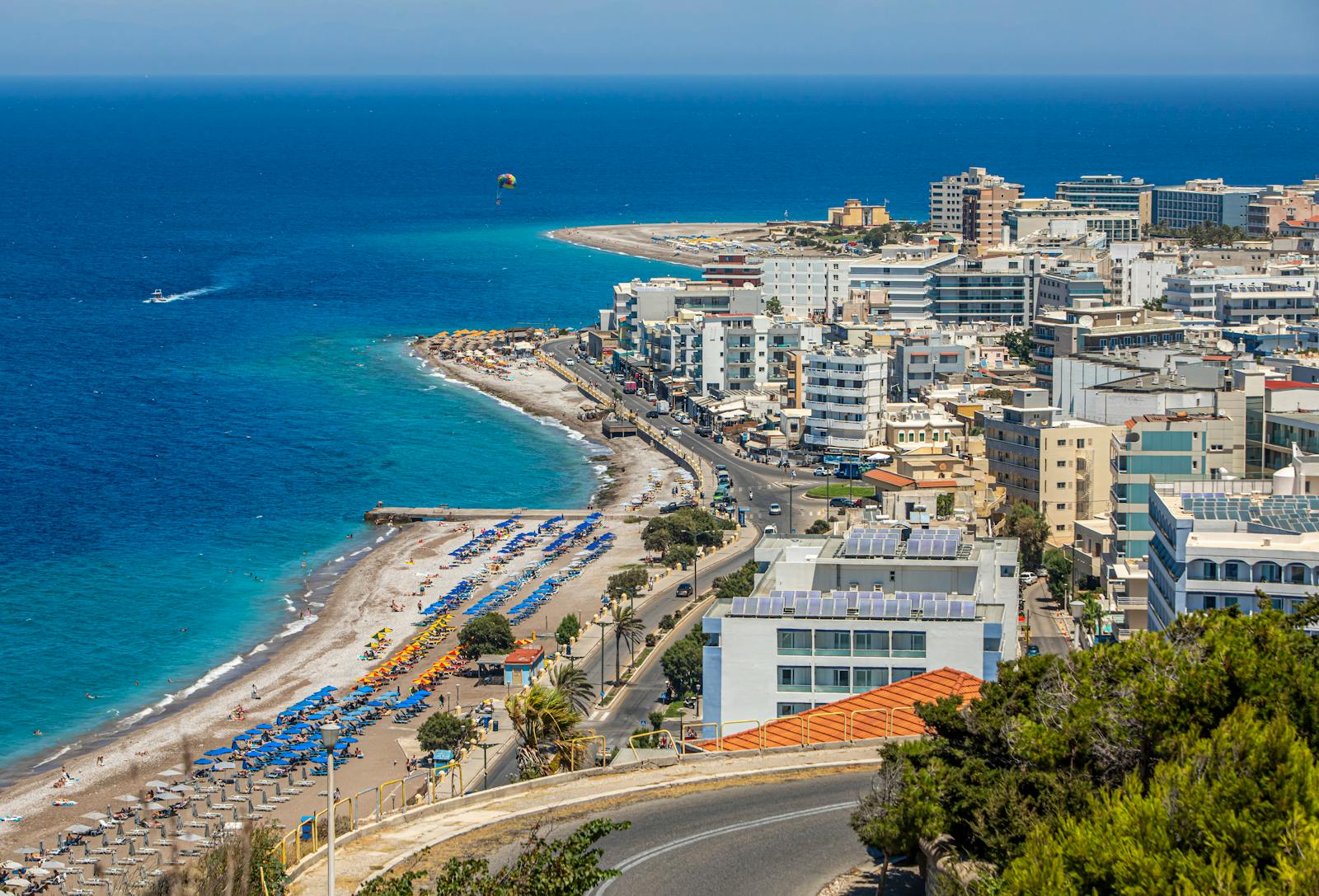 Superbe vue aérienne du paysage urbain et du littoral de Rhodes, mettant en valeur les plages animées et les eaux azur.